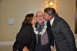 Prof. Linderski enjoys the affections of his former student Hans-Freidrich Mueller and Prof. Mueller's wife, Terri. | Photo by Tina Turner